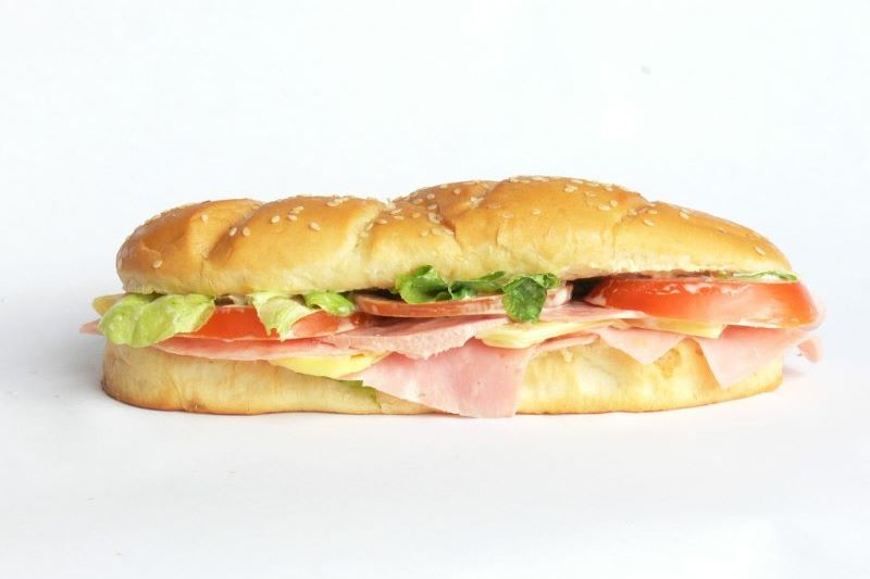 Rustic baguette with filling of ham and salad